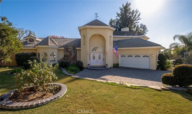 view of front of property featuring a front lawn and a garage