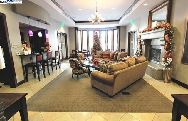 tiled living room with crown molding, a raised ceiling, and a notable chandelier