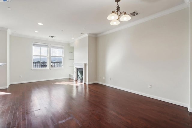 unfurnished living room with dark wood-type flooring, an inviting chandelier, and ornamental molding