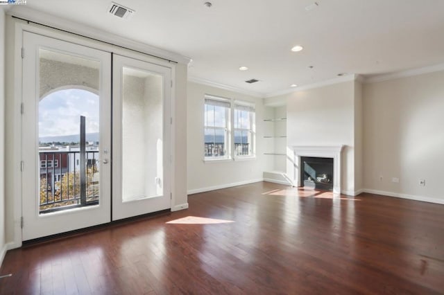 unfurnished living room featuring dark hardwood / wood-style floors, ornamental molding, and french doors