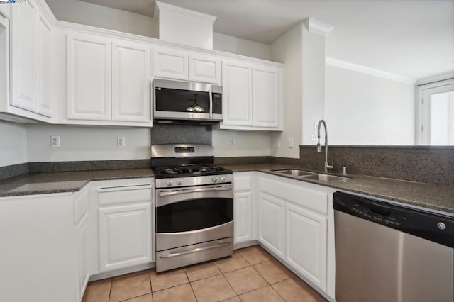 kitchen with light tile patterned floors, white cabinets, appliances with stainless steel finishes, and sink