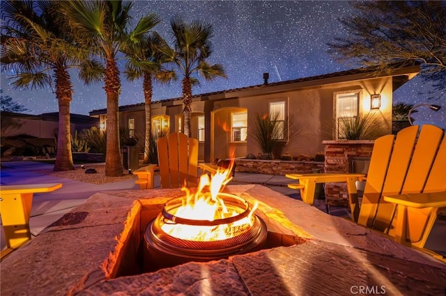 rear view of house with a patio and a fire pit