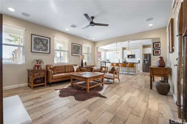 living room with light hardwood / wood-style floors and ceiling fan