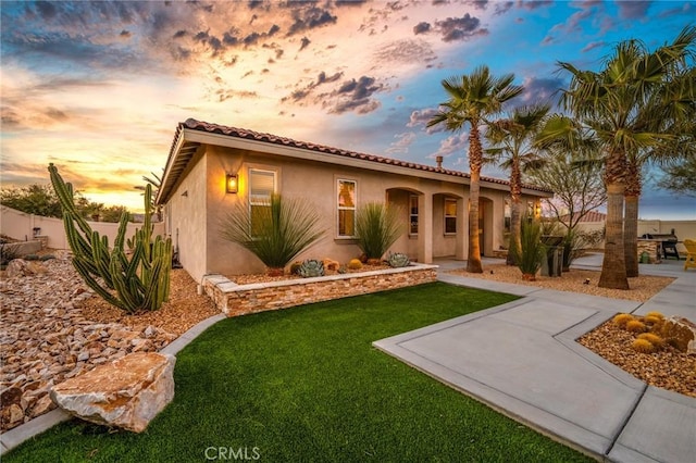 mediterranean / spanish house featuring a patio and a yard