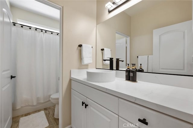 full bathroom featuring toilet, vanity, shower / bath combo with shower curtain, and hardwood / wood-style floors