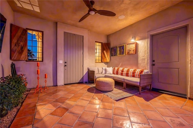 living area with ceiling fan and light tile patterned floors