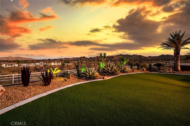 view of home's community with a mountain view and a lawn