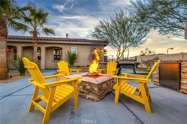 patio terrace at dusk featuring an outdoor fire pit