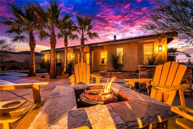 patio terrace at dusk featuring a fire pit