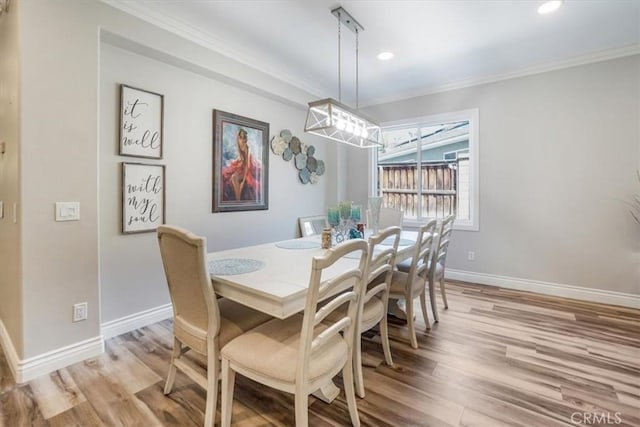 dining space with light wood-type flooring and crown molding