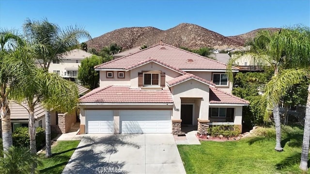 mediterranean / spanish-style home featuring a mountain view, a front yard, and a garage