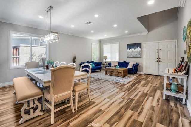 dining area with ornamental molding and hardwood / wood-style floors