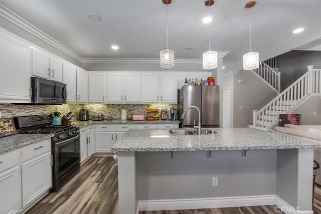 kitchen with white cabinetry, hanging light fixtures, stainless steel fridge, and black range with gas stovetop