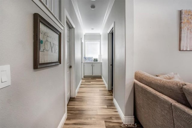 hall featuring light wood-type flooring and crown molding