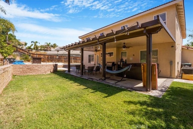 back of property featuring ceiling fan, a patio area, and a yard