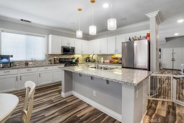 kitchen featuring sink, white cabinets, appliances with stainless steel finishes, and an island with sink