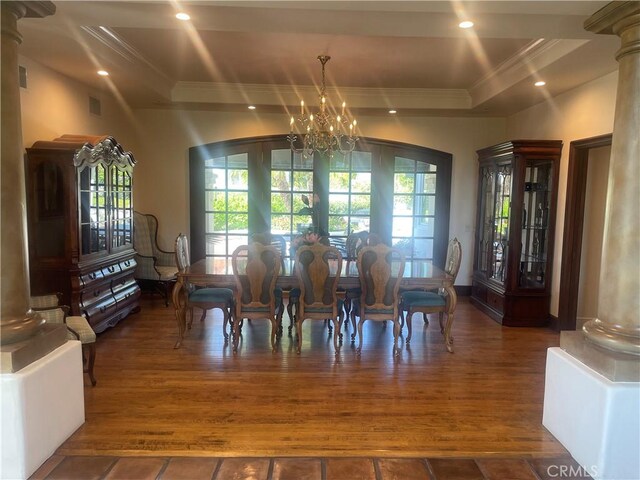 dining space with french doors, dark hardwood / wood-style floors, an inviting chandelier, and ornate columns