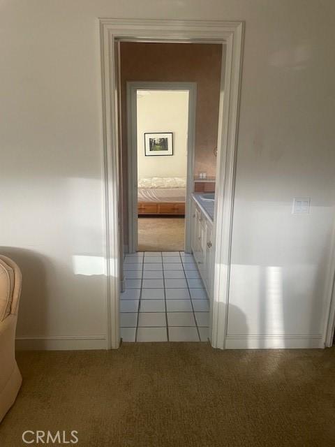 hallway featuring light colored carpet