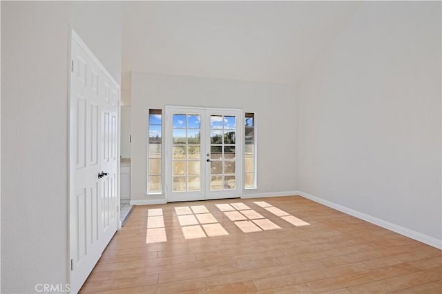 empty room with light hardwood / wood-style floors and lofted ceiling