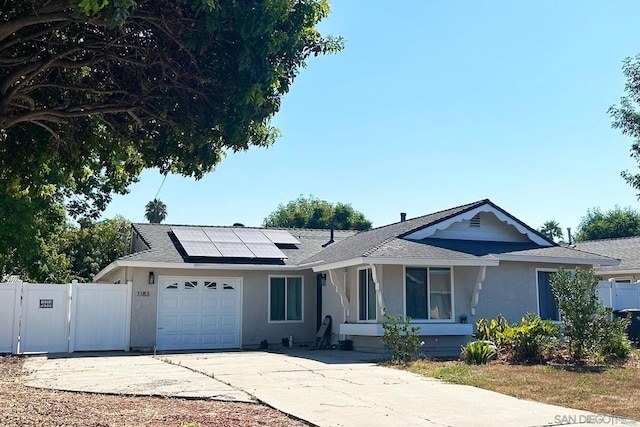 ranch-style home featuring solar panels and a garage