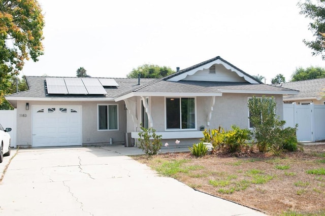 ranch-style house featuring solar panels and a garage