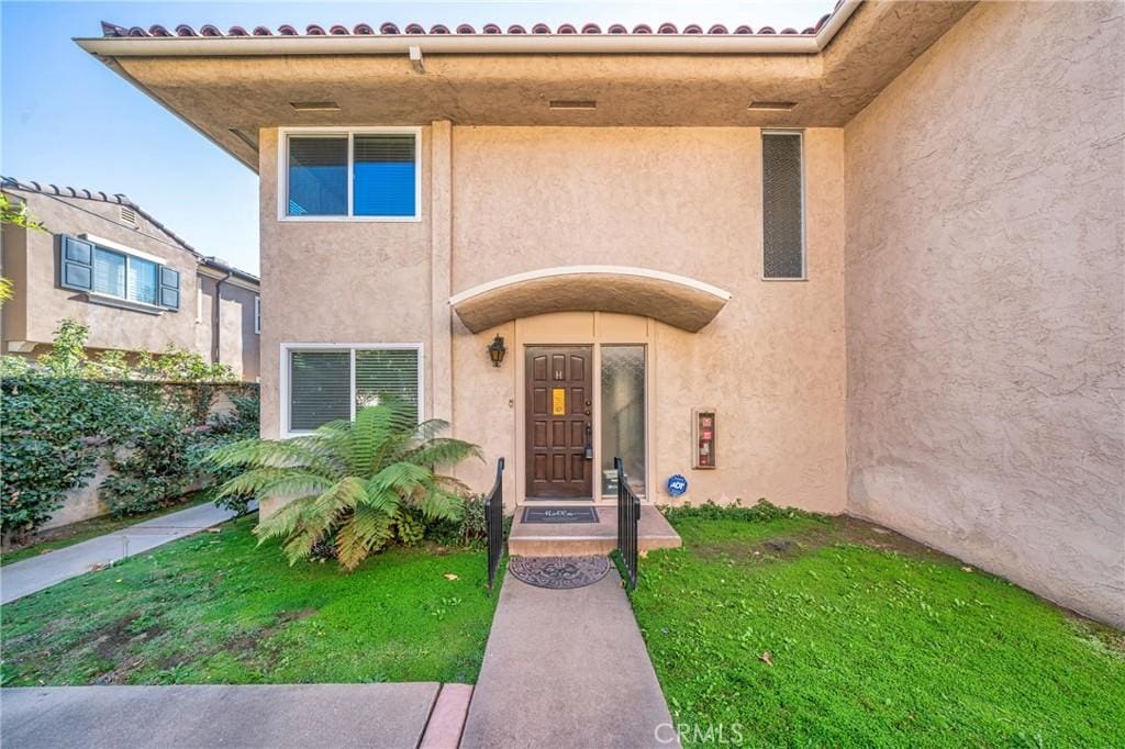 view of exterior entry with a yard