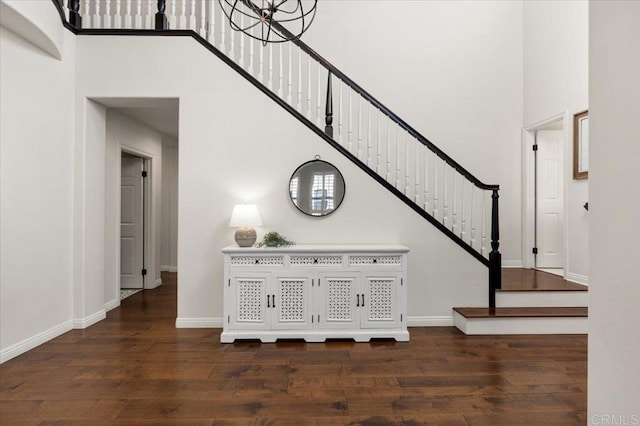 stairs with a towering ceiling and hardwood / wood-style flooring