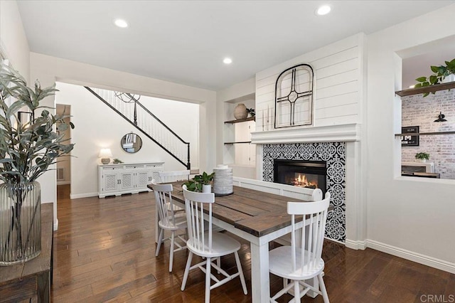 dining room with dark hardwood / wood-style flooring and a tile fireplace