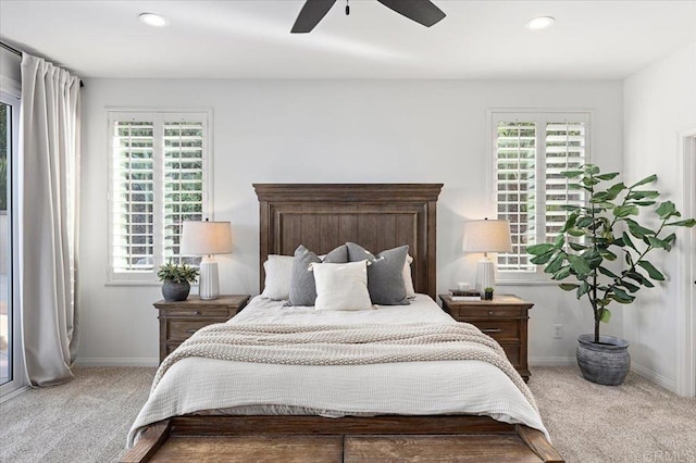 carpeted bedroom featuring ceiling fan and multiple windows