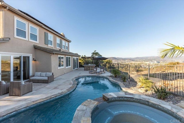 view of pool featuring an in ground hot tub, a patio area, and a mountain view