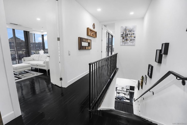 stairs featuring expansive windows and hardwood / wood-style flooring