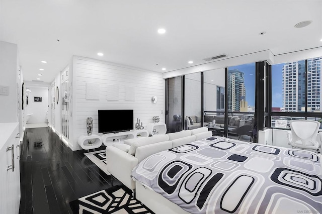 bedroom with floor to ceiling windows and dark hardwood / wood-style floors