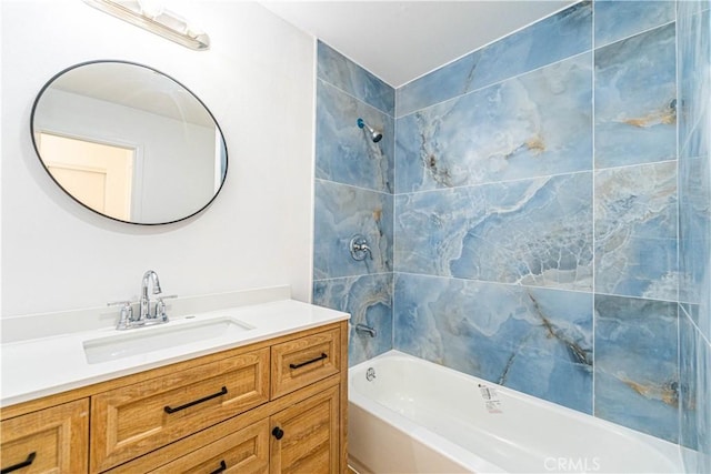 bathroom featuring tiled shower / bath combo and vanity