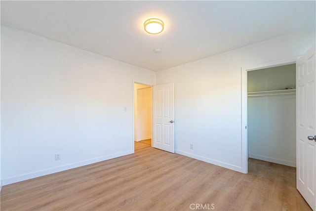 unfurnished bedroom with a closet and light hardwood / wood-style floors