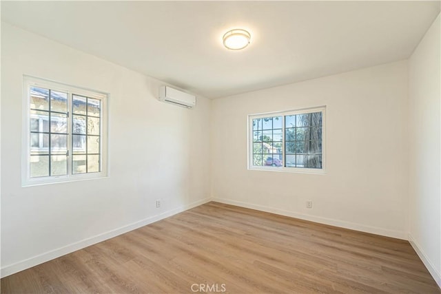 empty room featuring hardwood / wood-style floors and a wall unit AC