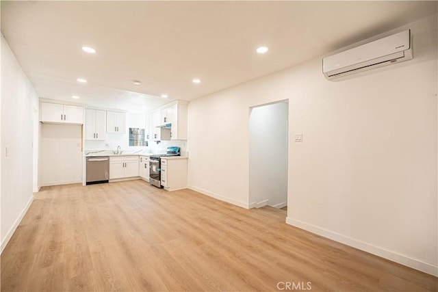 unfurnished living room with light wood-type flooring, sink, and a wall unit AC