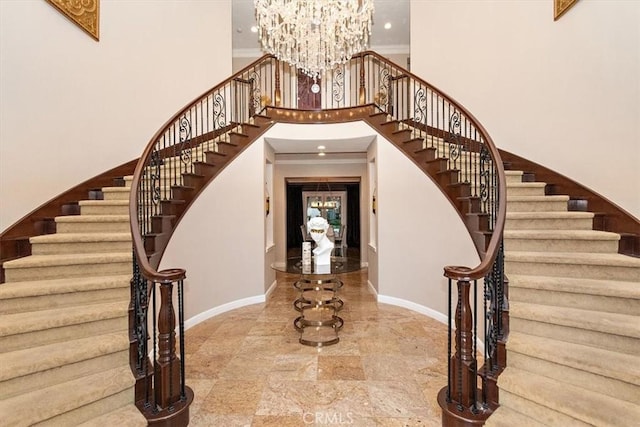 interior space featuring an inviting chandelier, a high ceiling, and ornamental molding