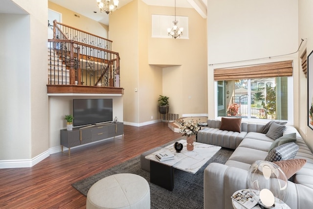 living room featuring a notable chandelier, a towering ceiling, and dark hardwood / wood-style floors