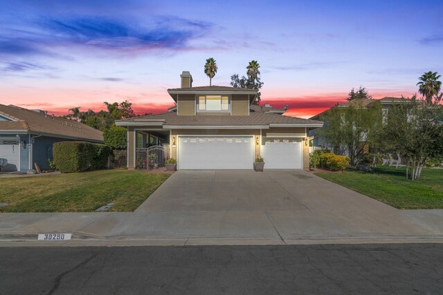 view of front of home featuring a garage and a lawn