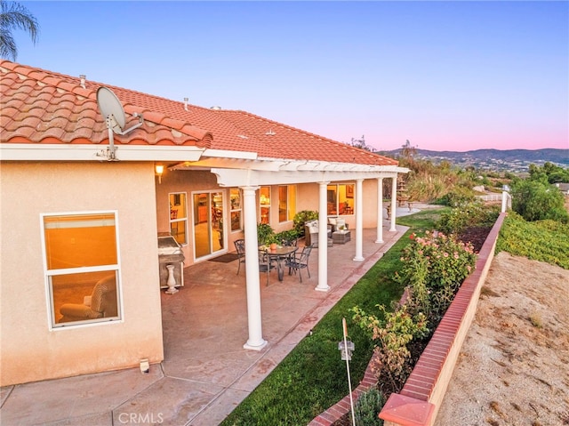 patio terrace at dusk featuring a pergola