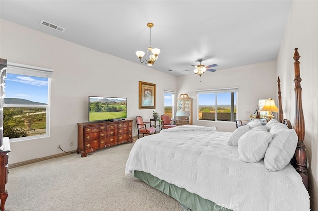 bedroom with ceiling fan with notable chandelier and light carpet