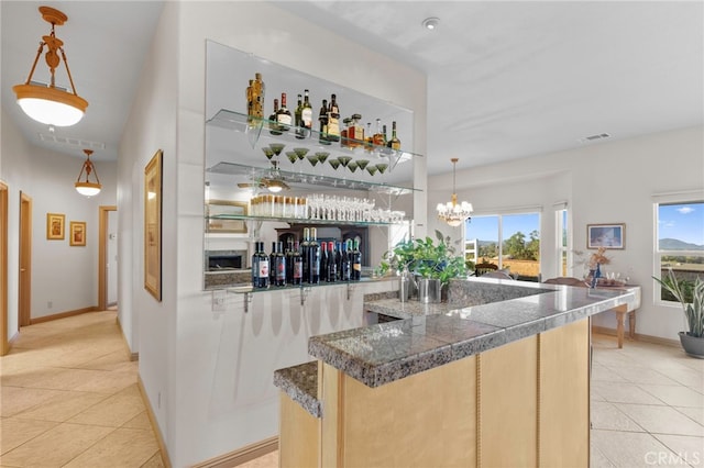 bar featuring light tile patterned floors, a wealth of natural light, and hanging light fixtures