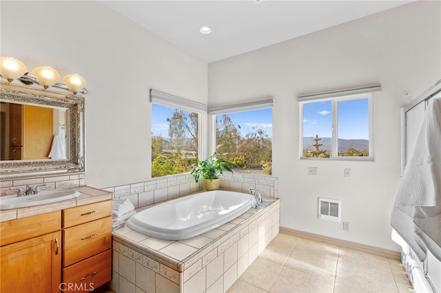 bathroom featuring vanity, tile patterned flooring, and a relaxing tiled tub