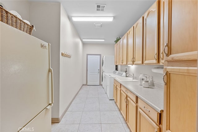 kitchen with white fridge, light tile patterned flooring, light brown cabinets, and sink