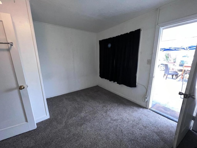 unfurnished room with dark colored carpet