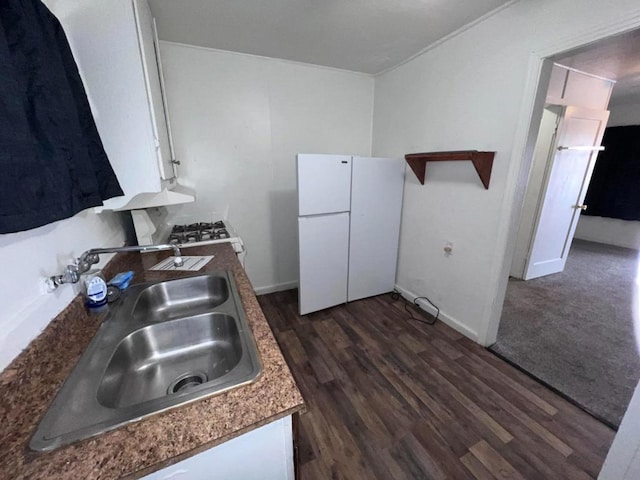 kitchen with white cabinetry, sink, and white refrigerator