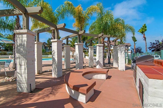 view of playground featuring an outdoor kitchen and a community pool