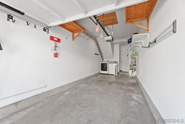 garage featuring a garage door opener and washer and dryer