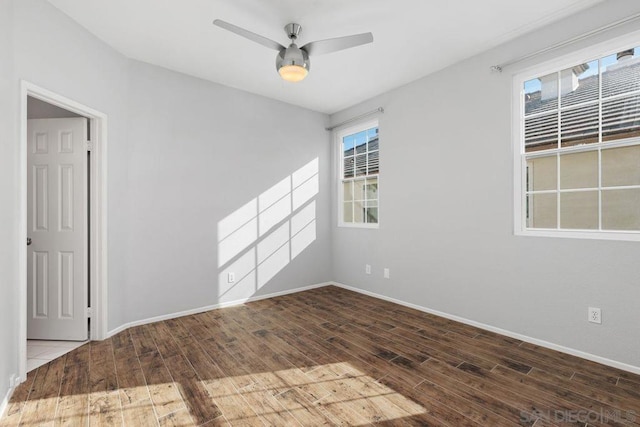 empty room with dark hardwood / wood-style flooring and ceiling fan