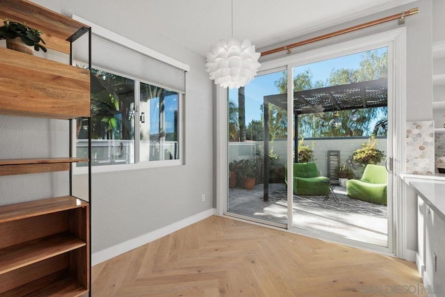 doorway featuring an inviting chandelier and light parquet floors